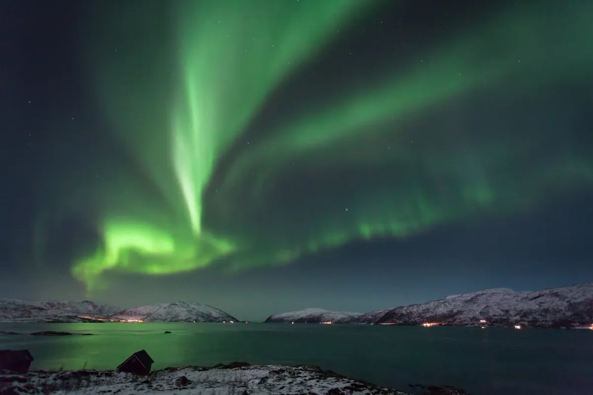 Northern lights over the sea at Kvaløya, the sky watched on this evening husky visit alongside husky dog sledding in Tromsø