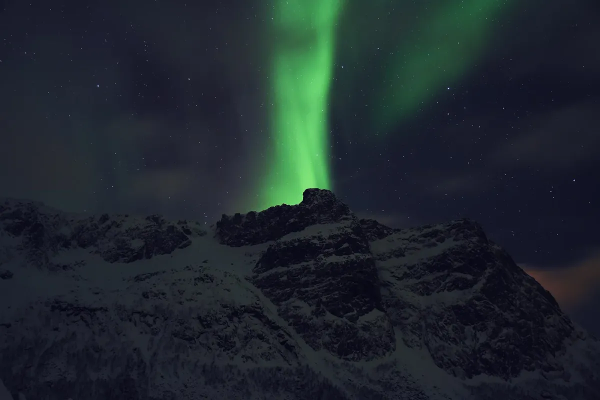 Northern lights over a mountain near Tromsø, the evening sky after a day of husky dog sledding in Tromsø